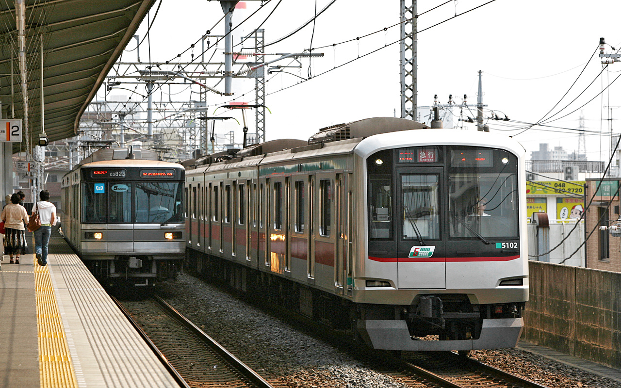 Tokyu 5000 series EMU set 5102 (right) and Tokyo Metro 03 series at the Yatsuka Station in Sōka city